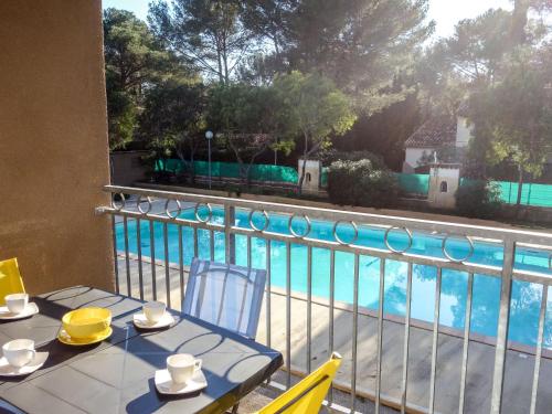 d'une table et de chaises sur un balcon avec vue sur la piscine. dans l'établissement Apartment La Marina by Interhome, à Bandol