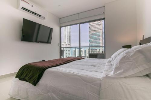 a bedroom with a large bed and a flat screen tv at Prity Apartamento in Cartagena de Indias