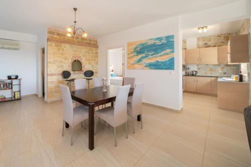 a dining room and kitchen with a table and chairs at Villa Mounda Apollon in Ratzaklíon