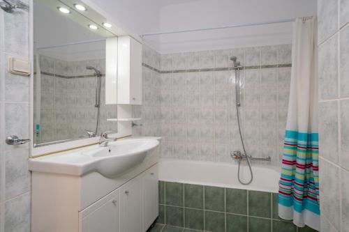 a white bathroom with a sink and a shower at Villa Mounda Hermes in Ratzaklíon