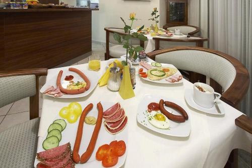 a table with plates of breakfast food on it at Hotel Penzion Na Hradě in Olomouc