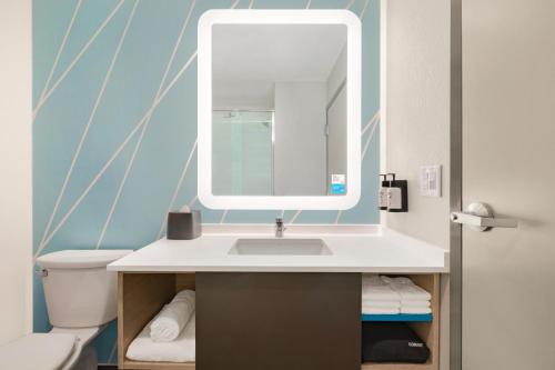 a bathroom with a sink and a mirror at avid hotels - Chicago O Hare - Des Plaines in Des Plaines