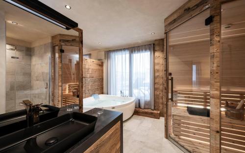 uma casa de banho com uma banheira e um lavatório e uma banheira em LaMonte Luxury Apartments em Kitzbühel