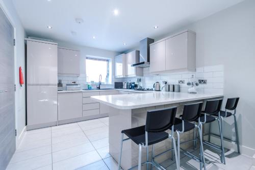 a kitchen with white cabinets and black bar stools at Weaver House in Chester