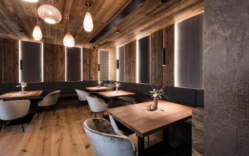 a restaurant with wooden floors and tables and chairs at LaMonte Luxury Apartments in Kitzbühel
