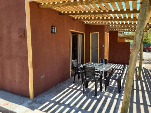 a patio with a table and chairs under a pergola at Cabañas Stommeln in Ovalle