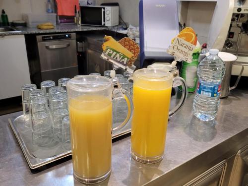 two glasses of orange juice sitting on a kitchen counter at Sol Playa in Valencia