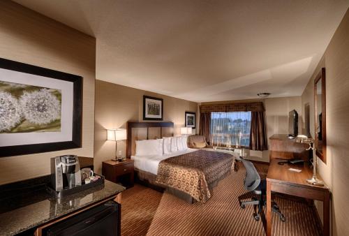 a hotel room with a bed and a desk at Canalta Hotel Lac La Biche in Lac La Biche