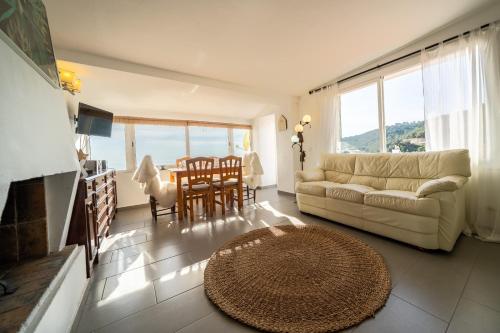 ein Wohnzimmer mit einem Sofa und einem Tisch in der Unterkunft Villa Vista Lux, Piscina privada y zona exterior con vista Mar in Tossa de Mar