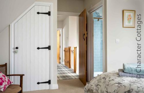 a bedroom with a door leading to a hallway at Hetty's Stables in Yanworth