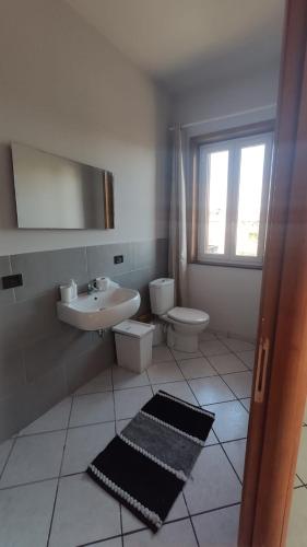 a bathroom with a sink and a toilet and a mirror at I capricci dell' Etna suite in Mascalucia