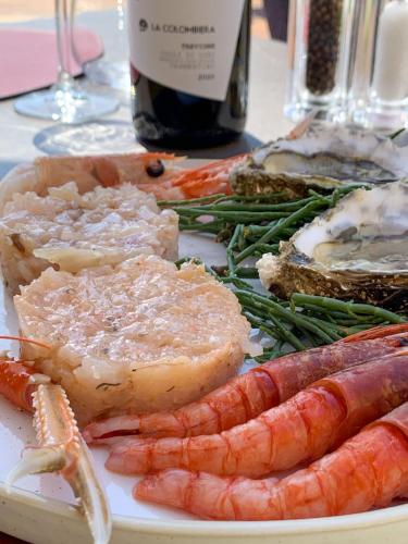 a plate of meat and vegetables with a bottle of wine at Grand Hotel Torre Fara in Chiavari
