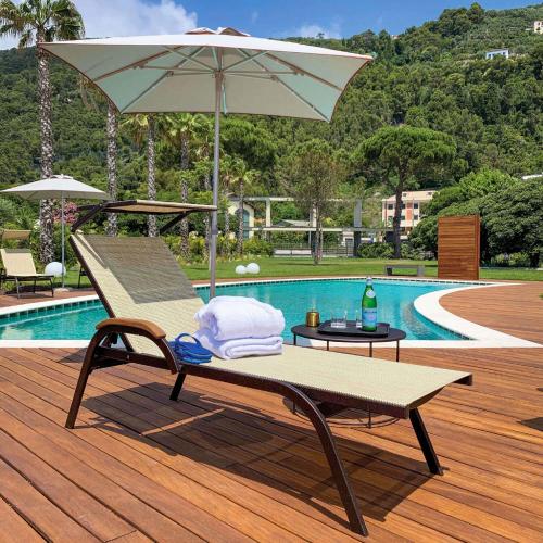 a chair with an umbrella next to a pool at Grand Hotel Torre Fara in Chiavari