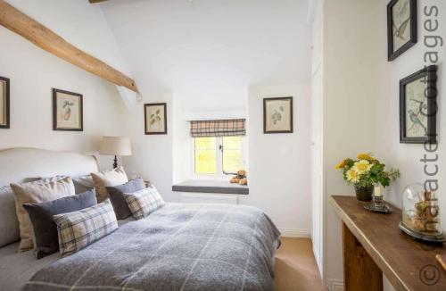 a bedroom with a bed and a window at Willow Cottage in Hampnett