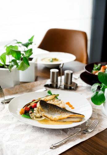 a table with a plate of fish on a table at ADAM Hotel Suites in Tunis