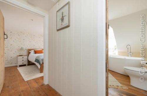 a bathroom with a bed and a tub and a sink at Copperbeech in Stow on the Wold