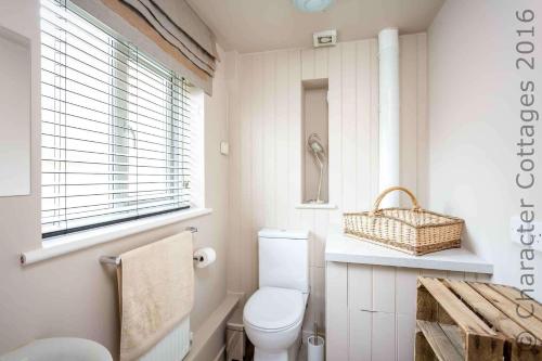 łazienka z toaletą, umywalką i oknem w obiekcie Honeysuckle Cottage Middle Tysoe w mieście Middle Tysoe