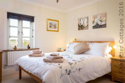 1 dormitorio con 1 cama con toallas en Headford Cottage, en Stow on the Wold