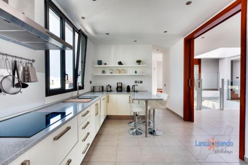 a kitchen with white cabinets and a table in it at Casa Blanca Teguise in Teguise