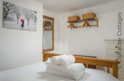 a pile of towels sitting on a bed in a room at Wyncliffe in Chipping Campden