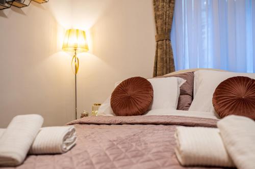 a bedroom with a bed with pillows and a lamp at Cosy&Private,30sec walk to MainSquare, Heart of Zagreb in Zagreb