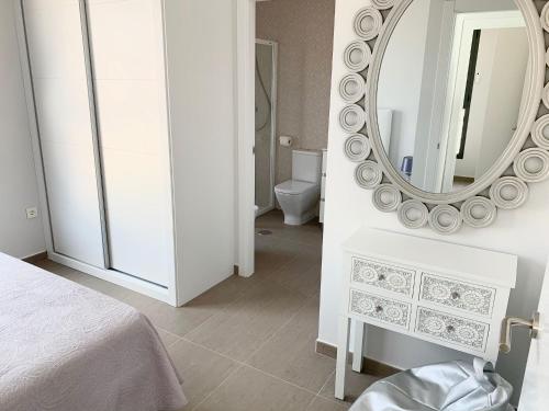 a white bedroom with a mirror and a bed at Apartamento Infinium I - Exclusivo - Inmodream Calpe in Ifach