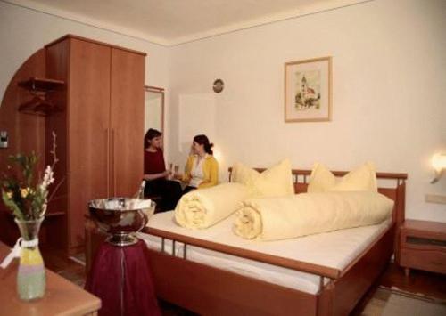 two women standing in a room with a bed at Retzerlandhof Familie Graf in Zellerndorf