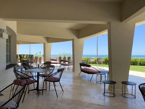 a patio with tables and chairs and the ocean at Grand Hotel Torre Fara in Chiavari