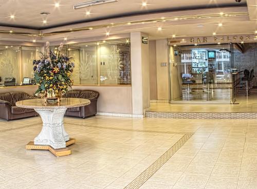 a lobby with a table with flowers on it at HM Mirador in Chihuahua