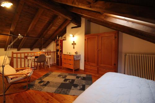 1 dormitorio con cama, escritorio y silla en La Casetta in Montagna Roisod - Affitti Brevi Italia, en Gignod