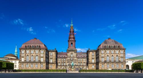 a large building with a clock tower in front of it at City Apartment With Exposed Ceiling Beams in Copenhagen