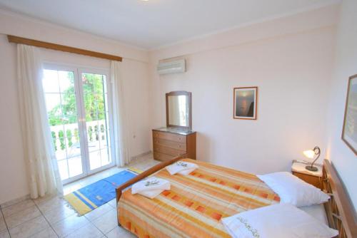 a bedroom with a bed and a large window at Dolphin House in Porto Ozias
