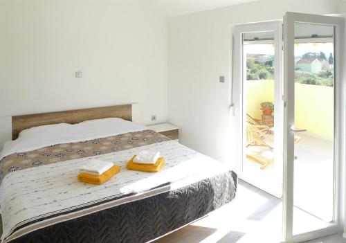 a bedroom with a bed with two yellow towels on it at Apartments Sunset in Olib