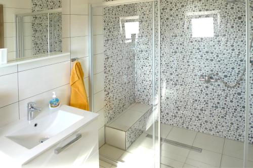 a bathroom with a glass shower and a sink at Apartments Sunset in Olib