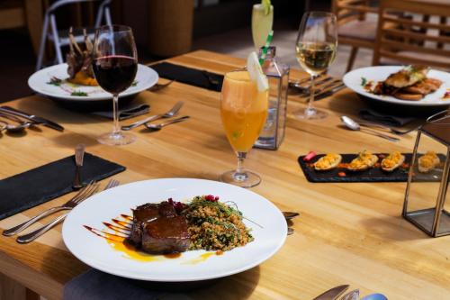 uma mesa com pratos de comida e copos de vinho em Hotel La Casa de Don Tomás em San Pedro de Atacama