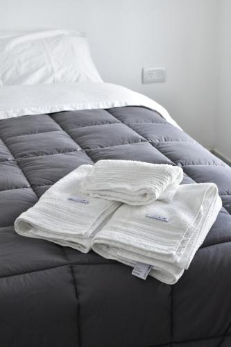 einen Haufen weißer Handtücher auf dem Bett in der Unterkunft DEPTO KENIA II. ALQUILER TEMPORARIO SAN FRANCISCO in San Francisco