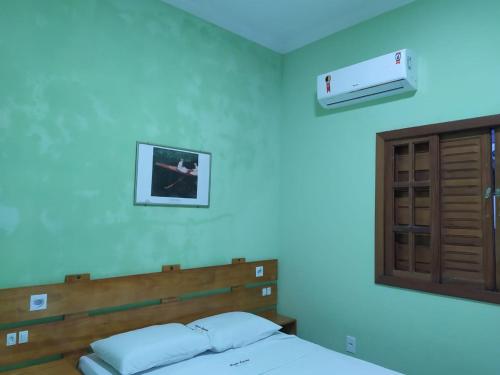 a bedroom with a bed and a air conditioner on the wall at Casa com piscina - Prado in Prado