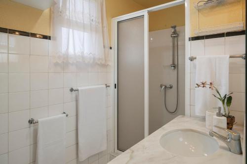a white bathroom with a sink and a shower at Casa dos Terços by An Island Apart in São Vicente