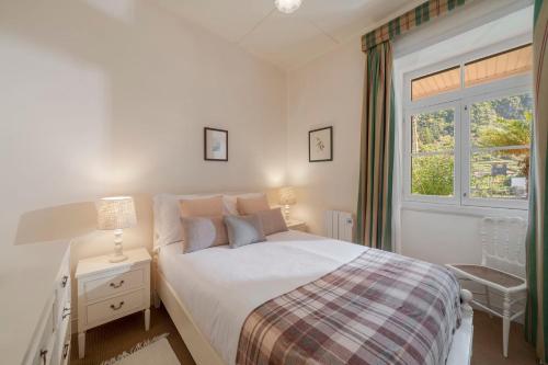 a bedroom with a white bed and a window at Casa dos Terços by An Island Apart in São Vicente