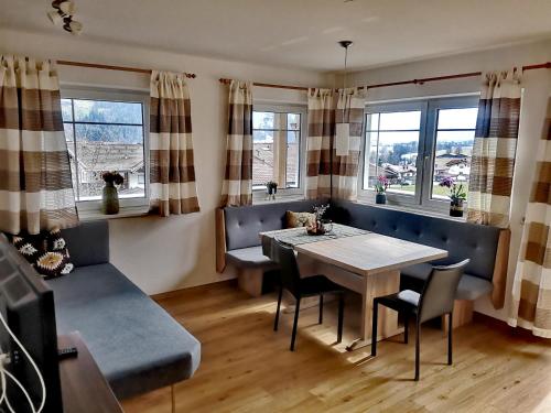 a dining room with a table and chairs and windows at Apartment Kolb in Hippach