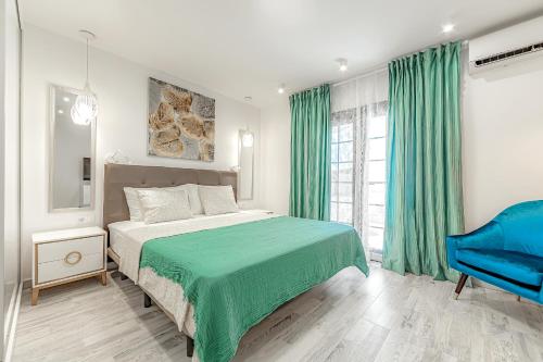 ein Schlafzimmer mit einem grünen Bett und einem blauen Stuhl in der Unterkunft Deluxe bungalow Perla Del Sur in Adeje