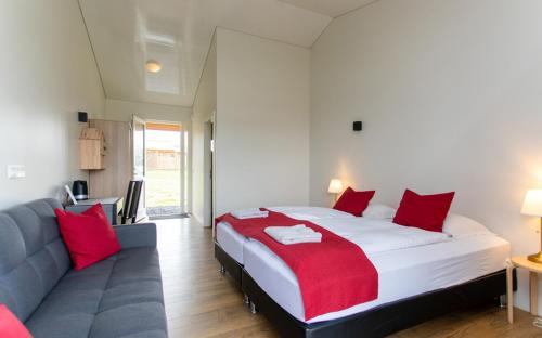 a bedroom with a large bed and a couch at Guesthouse Fludir - Grund in Fludir