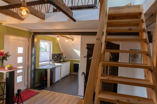 uma cozinha de conversão de loft e escadaria numa pequena casa em Maisonette am Glockenturm em Südbrookmerland