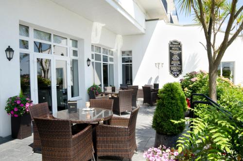 a patio with a table and chairs and plants at Majestic Hotel in Tramore