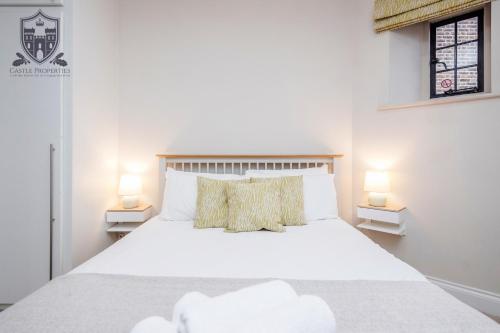 a bedroom with a white bed with two lamps at Castle Properties:Eton-The College in Windsor