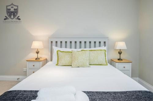 a white bed with two nightstands and two lamps at Castle Properties:Eton-The College in Windsor