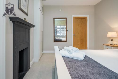 a bedroom with a fireplace and a bed with towels at Castle Properties:Eton-The College in Windsor