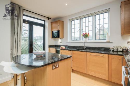 a kitchen with wooden cabinets and a counter top at Castle Properties:Eton-The College in Windsor