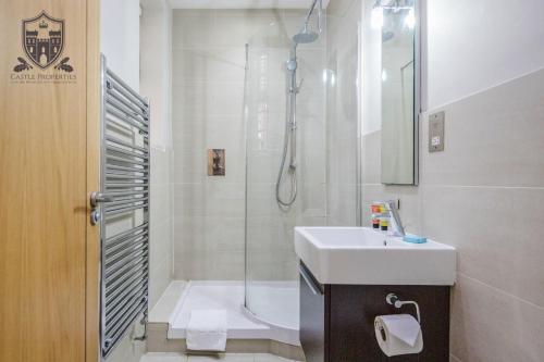a white bathroom with a sink and a shower at Castle Properties:Eton-The College in Windsor