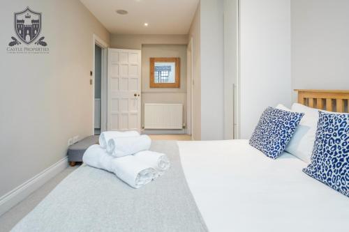 a bedroom with two white beds and a chair at Castle Properties:Eton-The College in Windsor